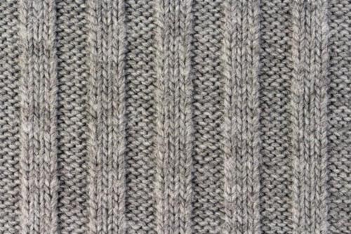 Knitting. Vertical striped gray knit fabric texture, knitted pattern background